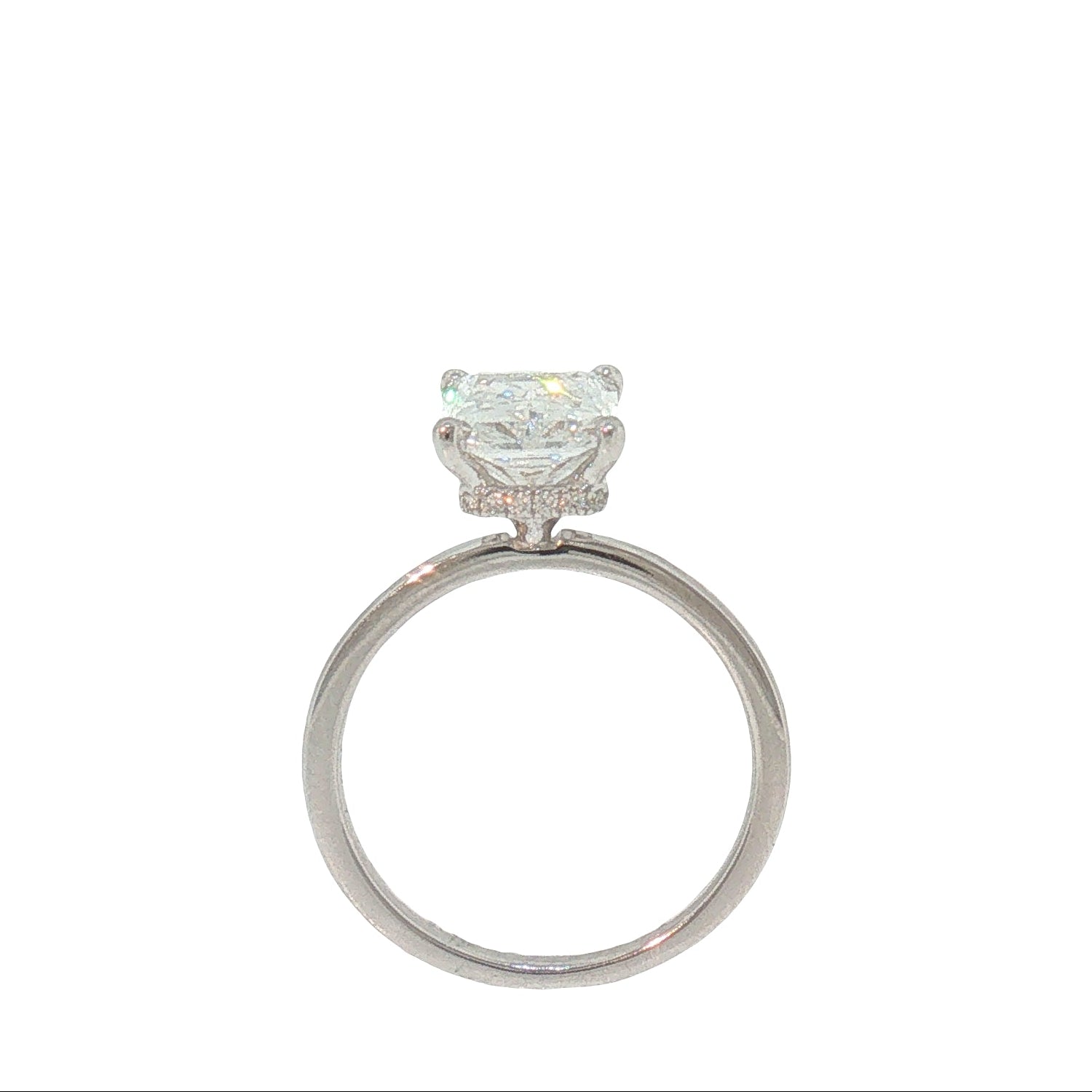 A silver-toned solitaire engagement ring featuring a rectangular clear gemstone in a prong setting, shown against a solid white background.