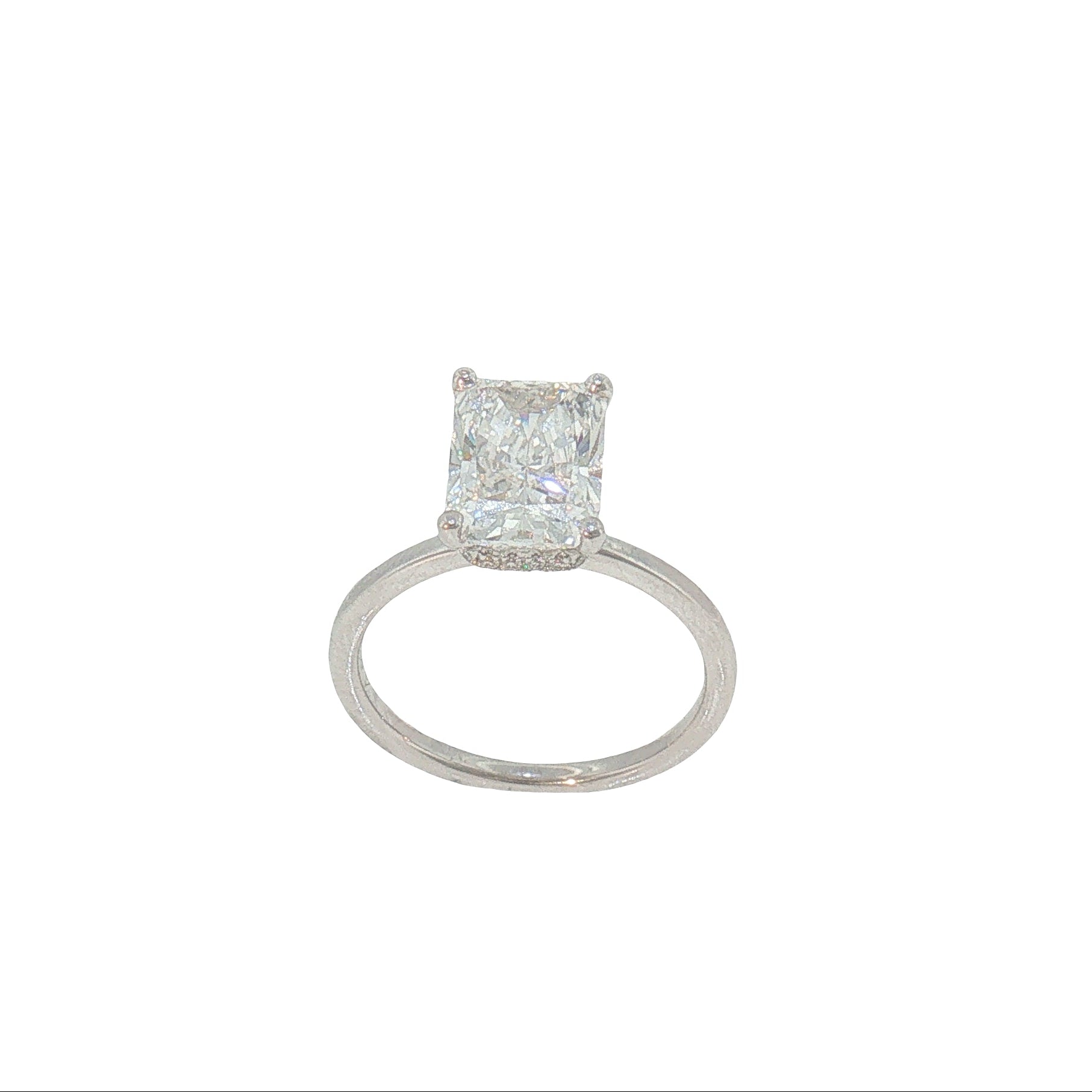 A radiant cut diamond engagement ring in a silver-colored metal band, centered on a plain white background.
