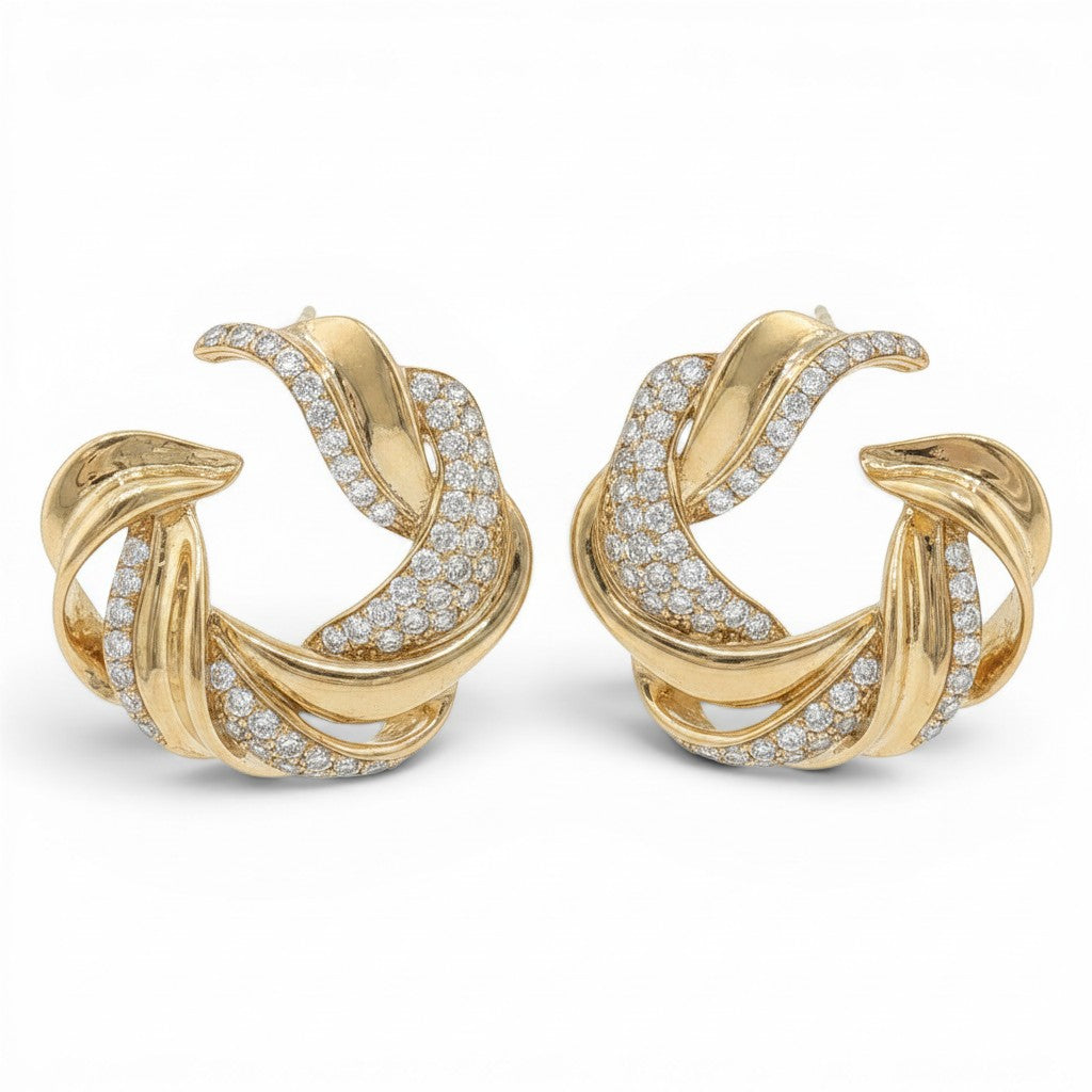 Bijoux Village Fine Jewellers 14K yellow gold swirl stud earrings featuring pavé set round brilliant-cut diamonds.