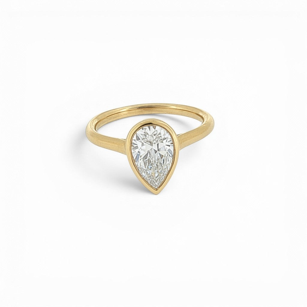Bijoux Village Fine Jewellers 14K yellow gold ring featuring a 1.40 carat pear-shaped diamond in a bezel setting.